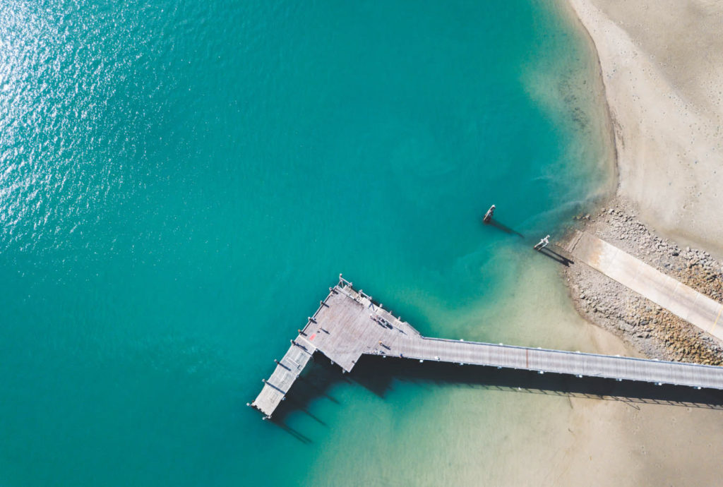 aerial drone photograph of ocean pier