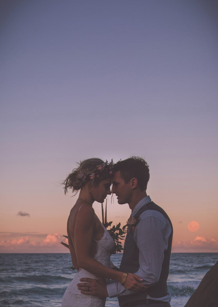 evening photograph of bride and groom with moon
