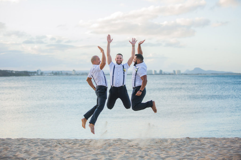 fun groomsmen photo at beach