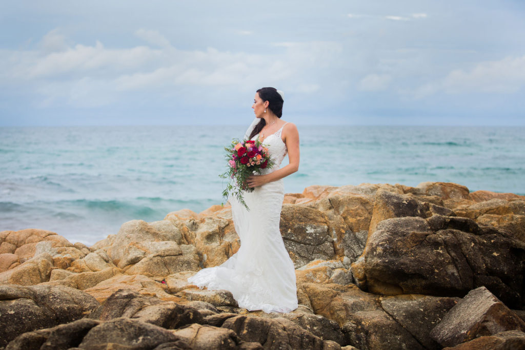 photo of bride looking out to sea on cloudy day