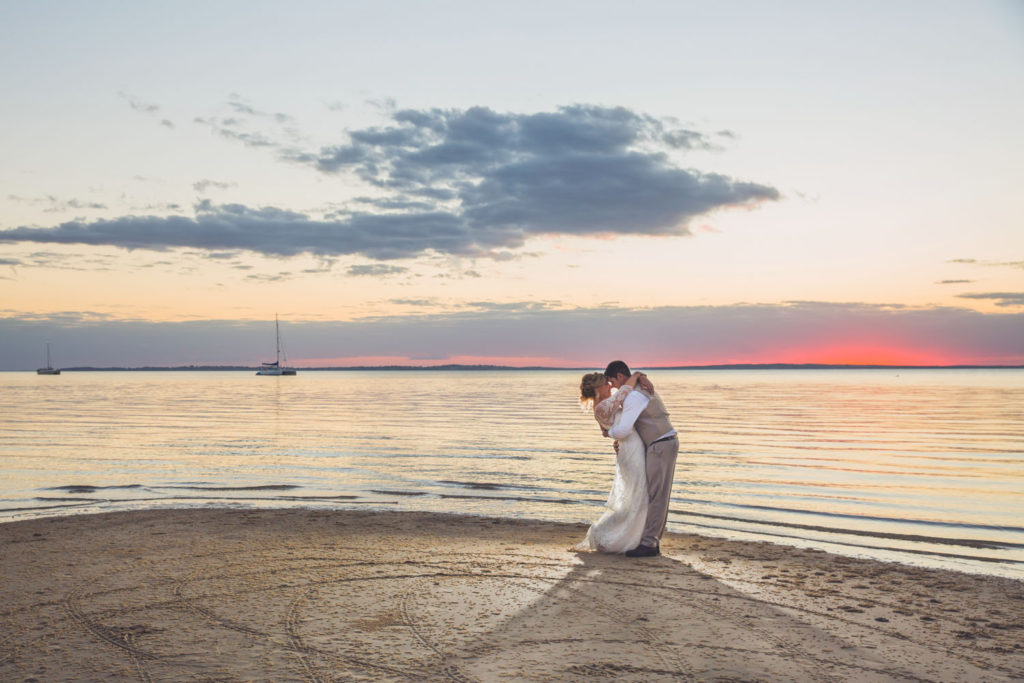 photograph of romantic beachside sunset kiss