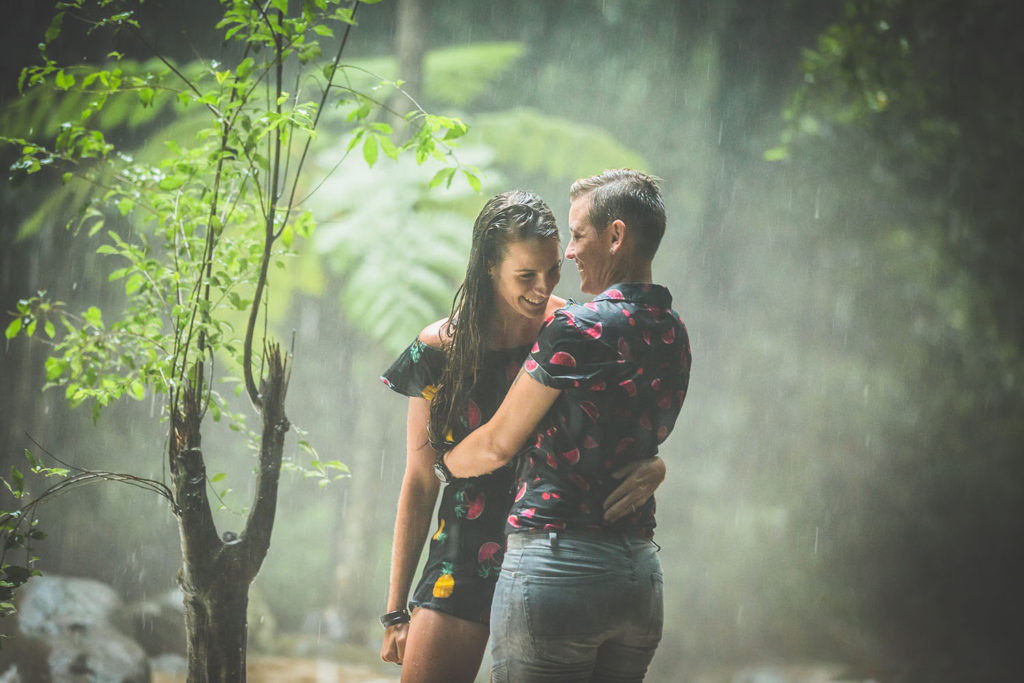 down to earth couple embrace in rain