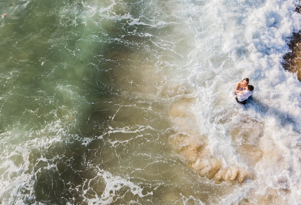 drone photograph of engaged couple in surf