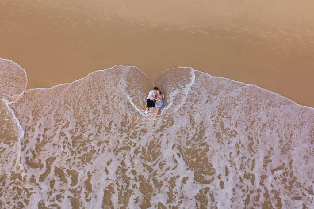 romantic aerial photograph of couple at beach
